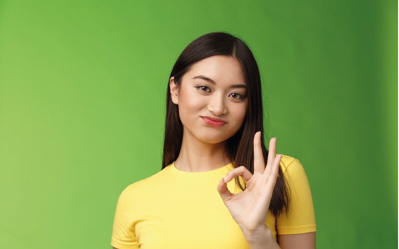 mulher asiática fazendo sinal positivo com a mão
